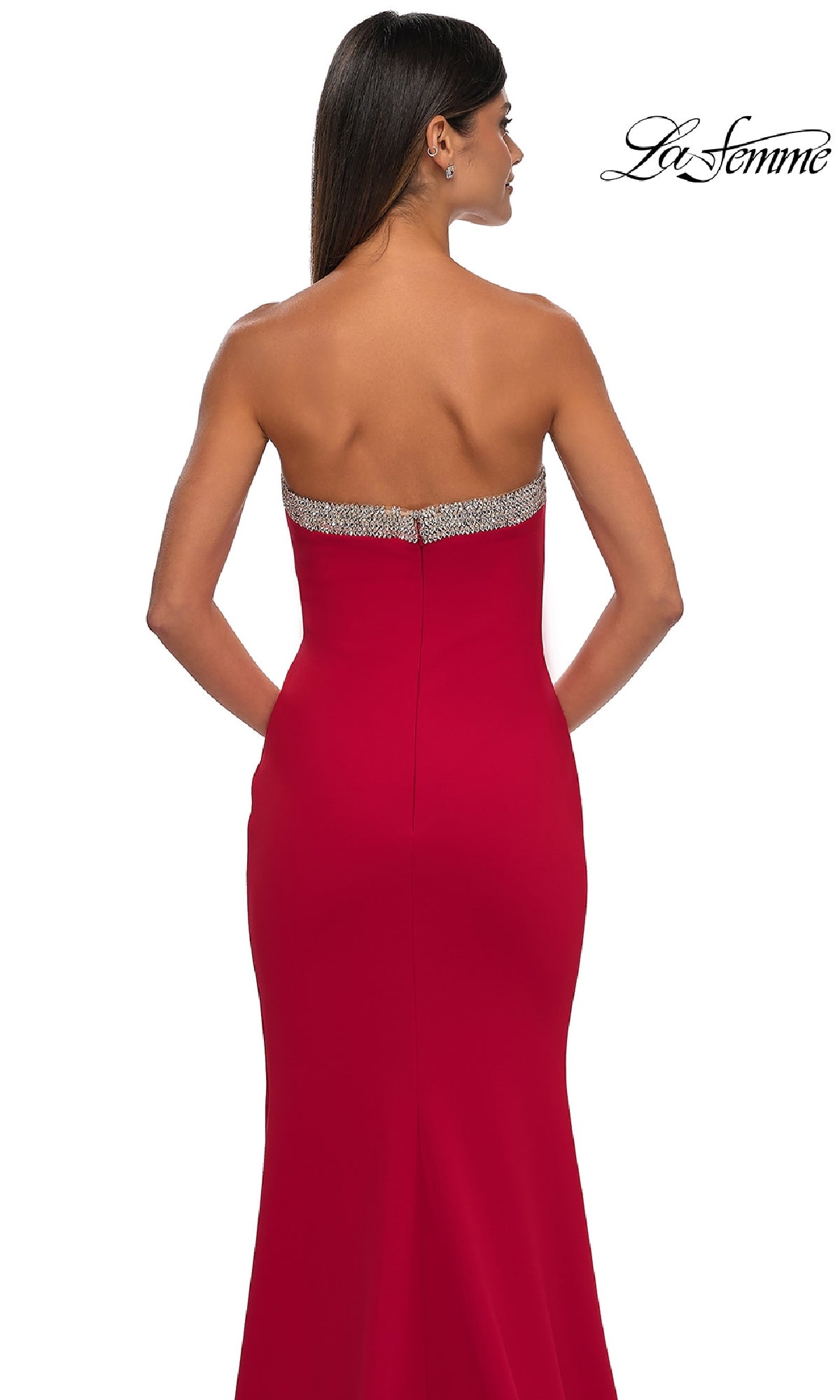 A woman with long dark hair and simple earrings is seen from the back wearing the Bead-Trimmed Long Prom Dress: La Femme 32891, a strapless formal gown featuring a jeweled band along the top for a stunning prom look.
